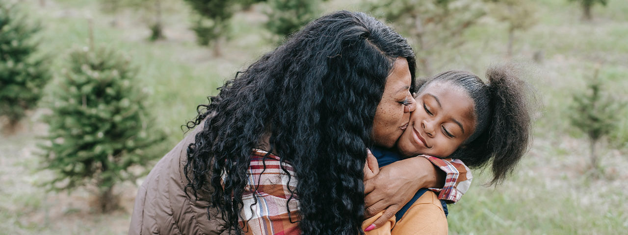 Woman kissing young girl in Goodlettsville | Dry Eye And Myopia Management at Kelly Vision Center