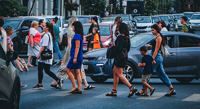 Pedestrians walking across busy urban crosswalk